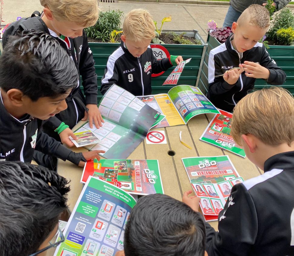 Kinderen verzamelen en ruilen voetbalplaatjes van lokale teams bij een voetbalplaatjesactie, georganiseerd door de supermarkt voor klantloyaliteit en lokale betrokkenheid.